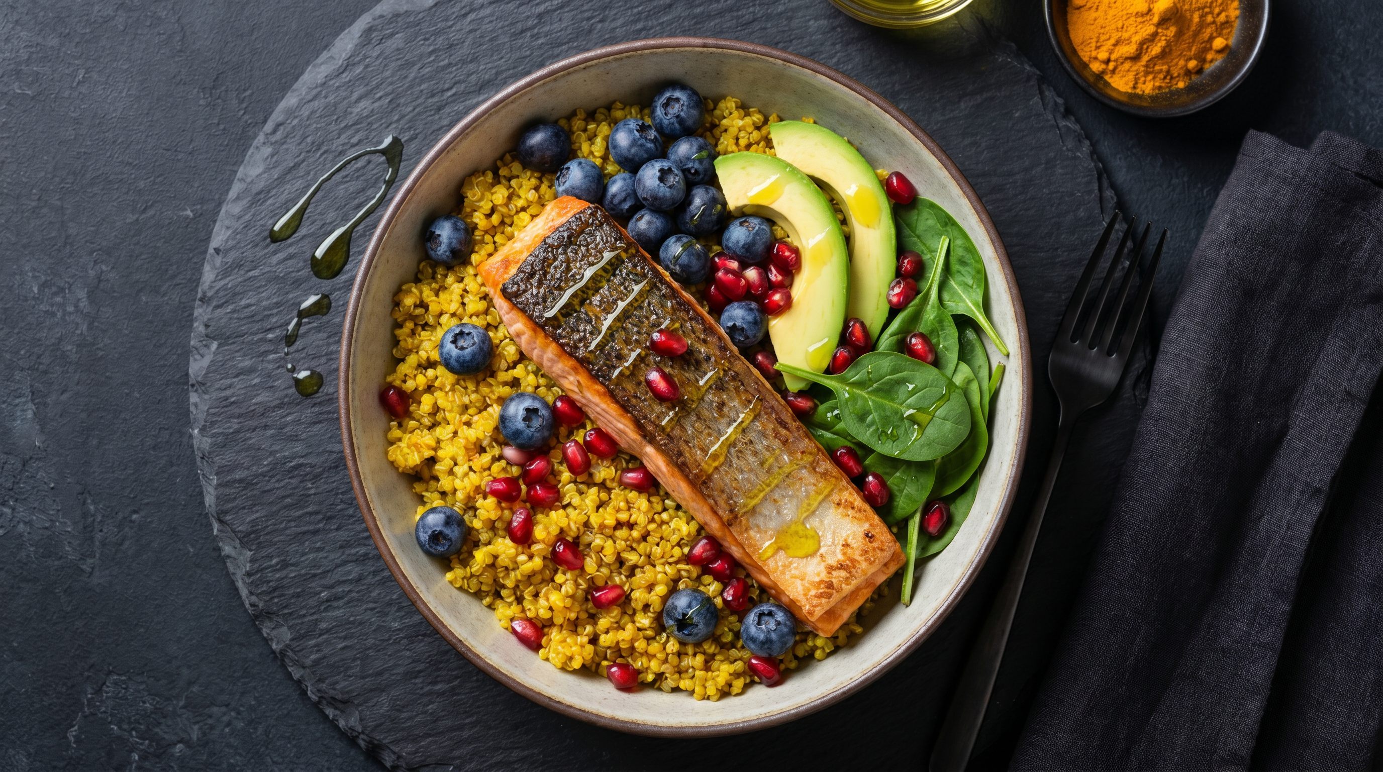 Anti-inflammatory foods: salmon, berries, walnuts, leafy greens, olive oil, and turmeric arranged on a clean surface